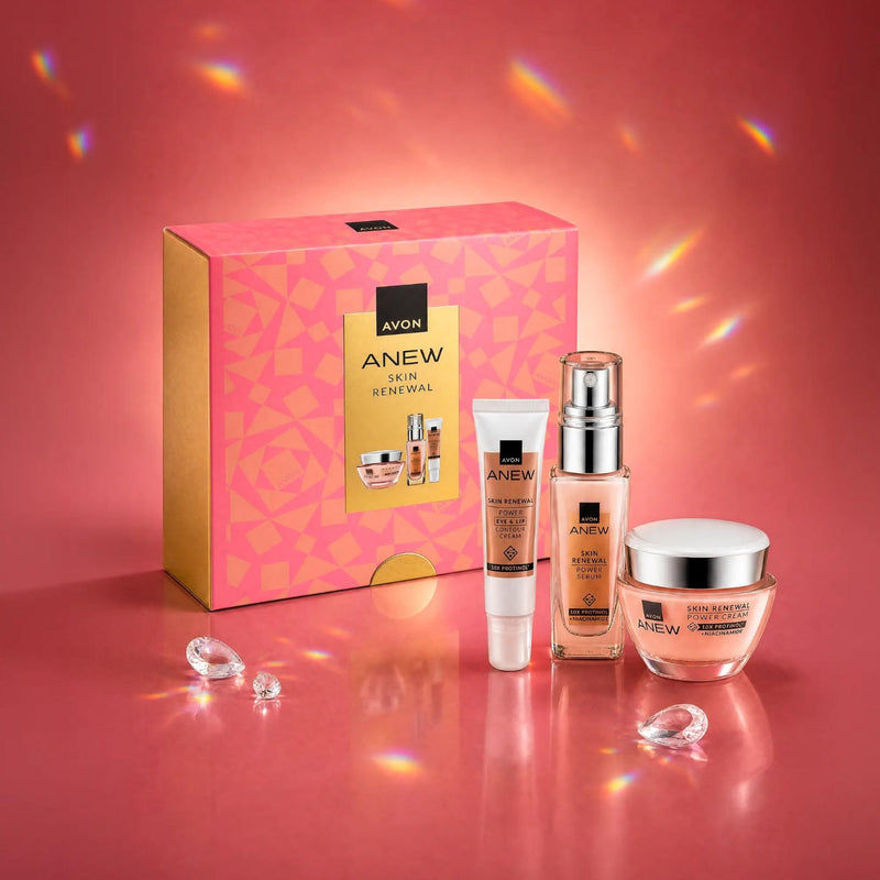 Avon Anew Skin Renewal gift set featuring a pink and gold box, a power serum bottle, an eye cream tube, and a jar of power moisturising cream, arranged on a pink reflective surface.