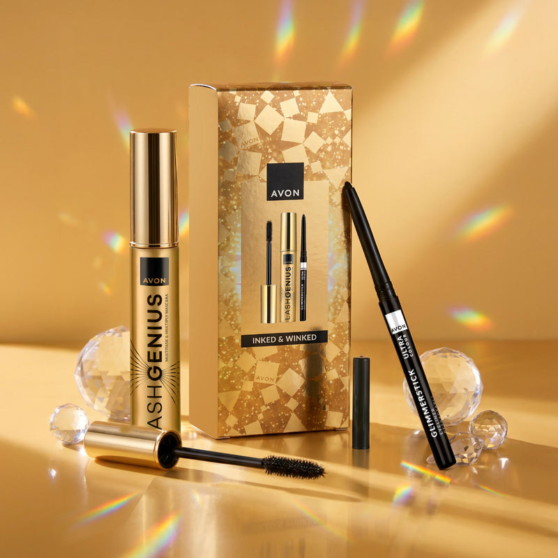 Avon Lash Genius Waxed & Winked makeup set with a gold Lash Genius mascara tube, black Glimmerstick eyeliner pencil, and patterned gold box on a reflective gold surface.