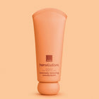 A squeeze tube of Avon Her Wisdom intensely Restoring Wonderbalm in a warm peach-orange color, centered against a matching solid peach background.